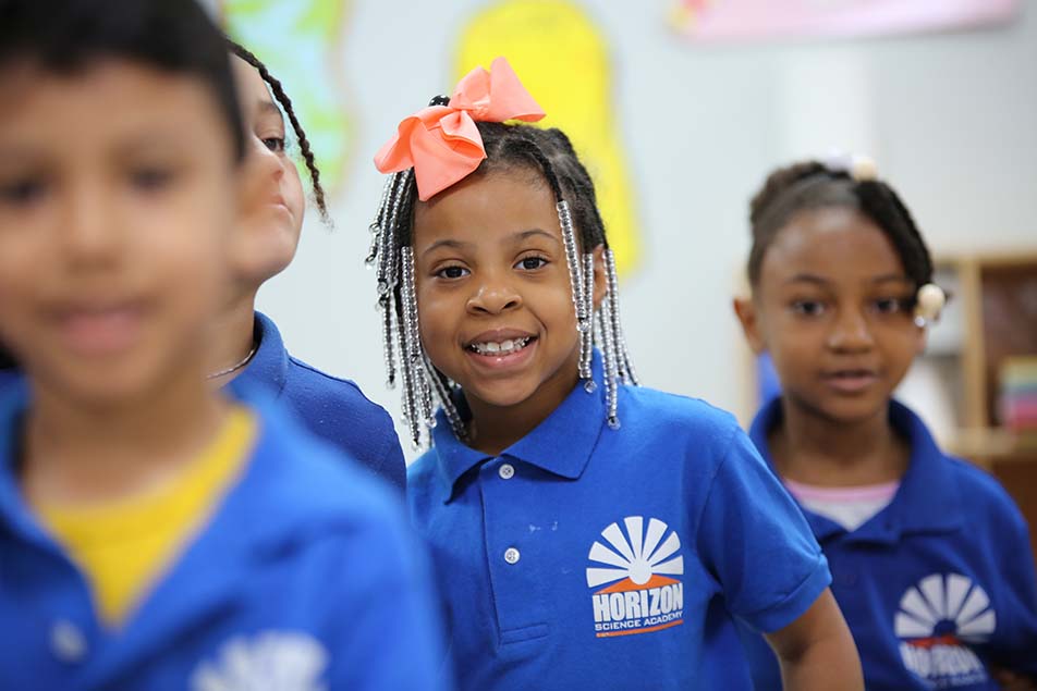 student in classroom smiling at camera